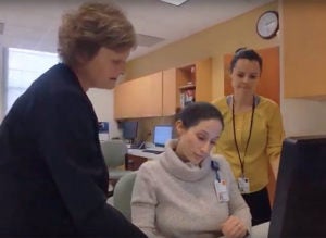 Three women gathered around a computer