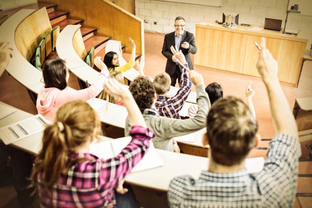 Photo showing students raising their hands to ask professor questions