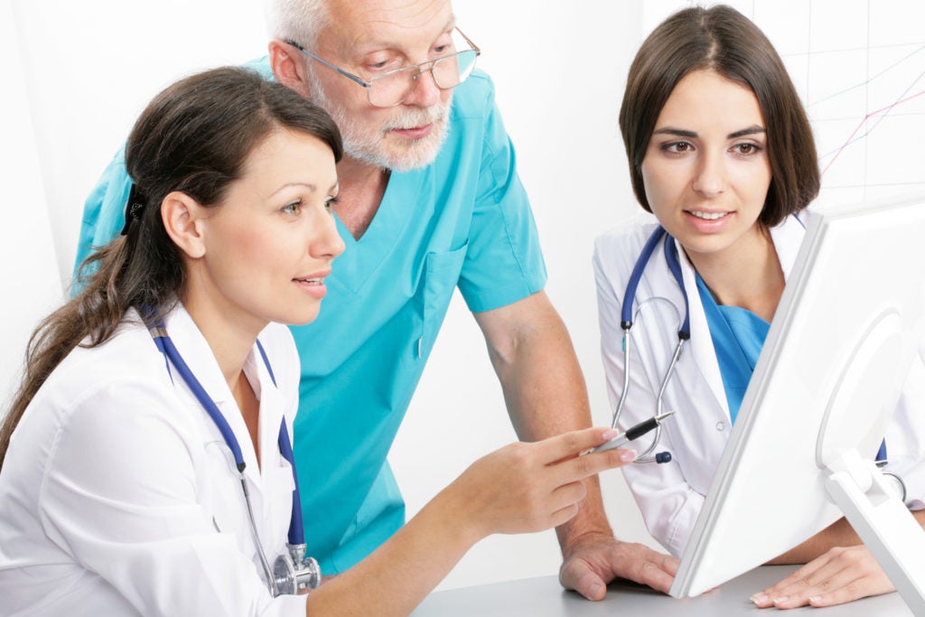 Photo showing three medical professionals talking together