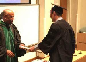 dean handing student diploma at graduation