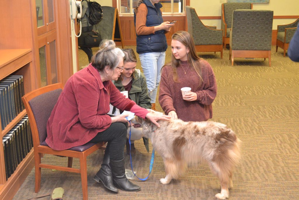 Students talking to volunteer about the therapy dog program.