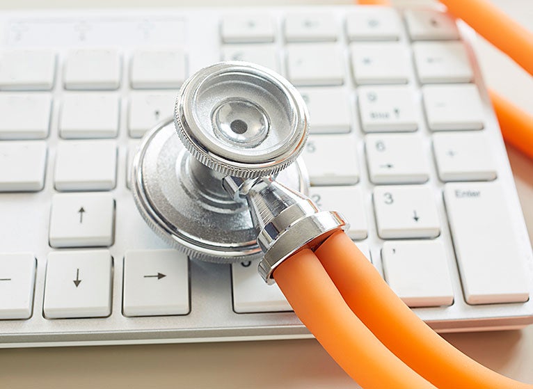 Stethoscope resting on a computer keyboard
