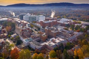 UVA Hospital arial photo set against background of the city of Charlottesville (Photo by Sanjay Suchak, University Communications)
