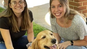 Two students and therapy dog