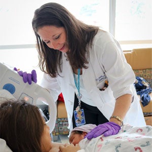 Ann Kellams, MD, helping new mother with breastfeeding.