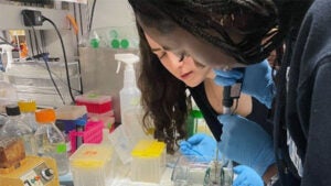 A UVA School of Medicine student assists a high school student in the lab.