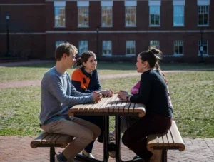 Students sitting at picnic table.