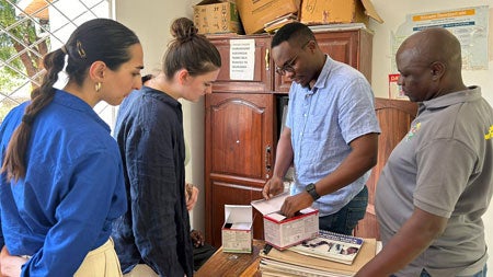 (From left) Tatev Gomtsyan (UVA student), Caroline Rich (UVA student), Dr. Frank Thobias Adel (Medical Doctor - KIDH), and Mr. Thobias Magati (MKUTA Coordinator - tuberculosis survivors group) examine clinical workflow.