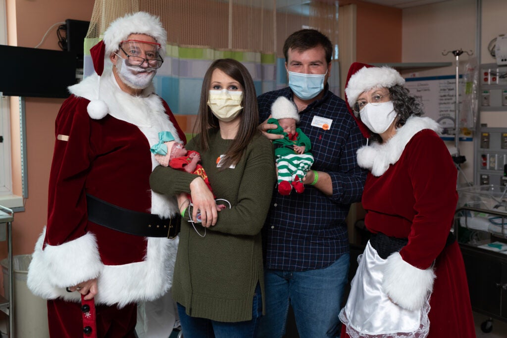 santa and mrs claus pose with nicu baby and family