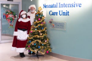 santa and mrs claus with christmas tree in front of NICU 